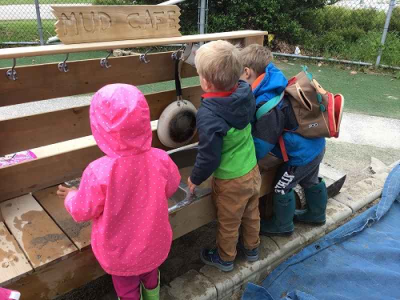 children playing in an outdoor mud kitchen